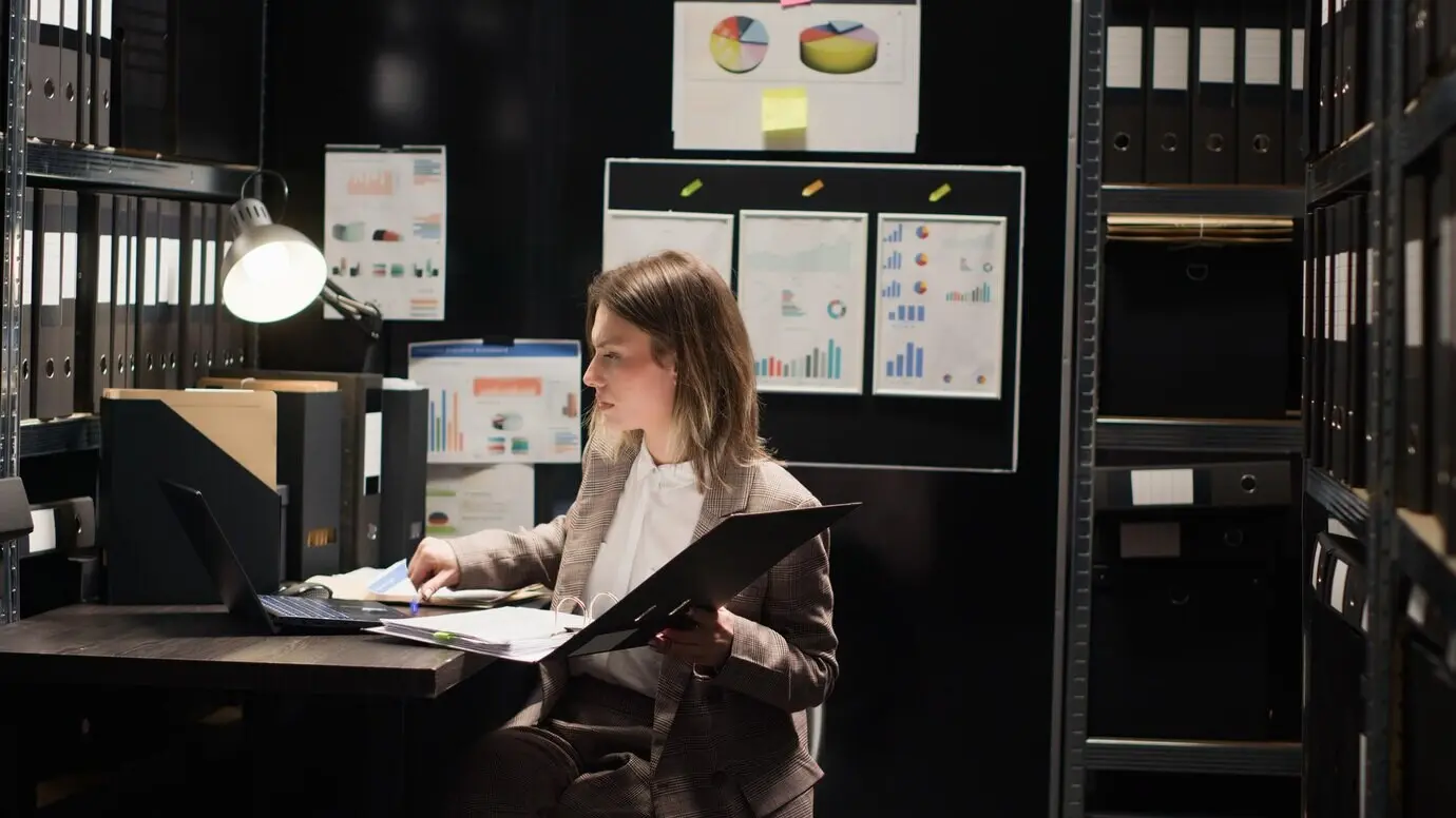 Un investigador entra en la oficina con una carpeta.